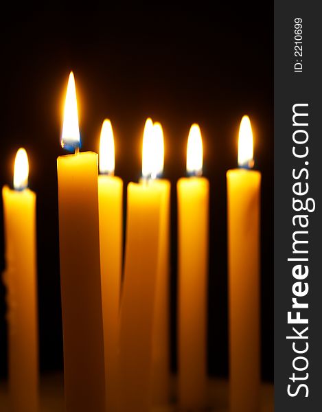 Romantic burning candles on black background