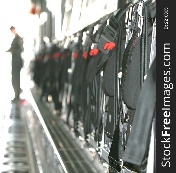 A row of jump seats folded up on C-5 airforce cargo plane. A soldier stands in the background out of focus. A row of jump seats folded up on C-5 airforce cargo plane. A soldier stands in the background out of focus.