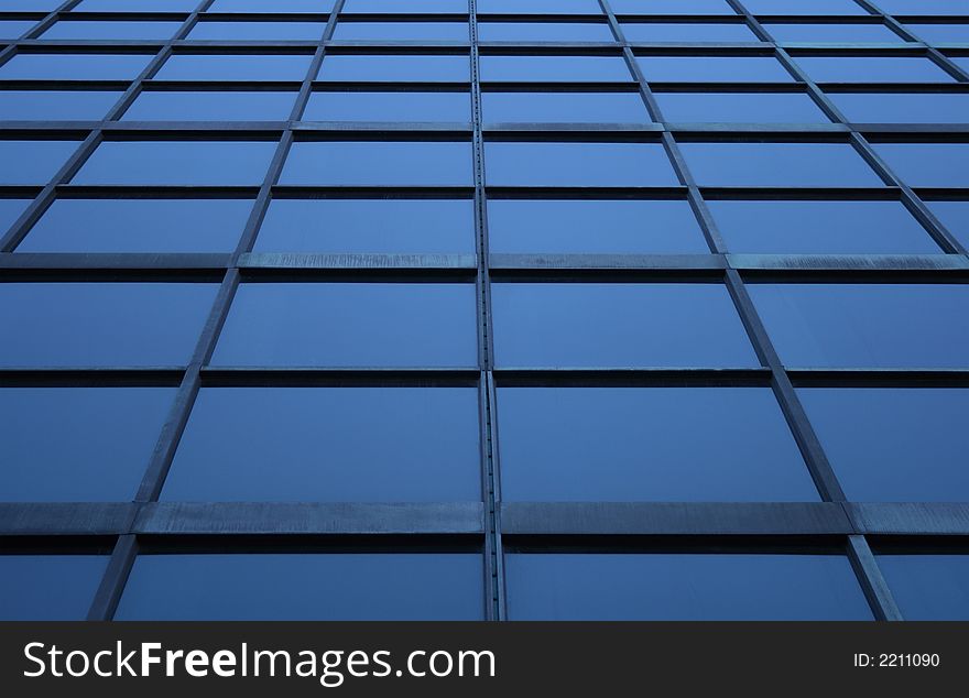 Blue glass panels of a skyscraper, perspective view.