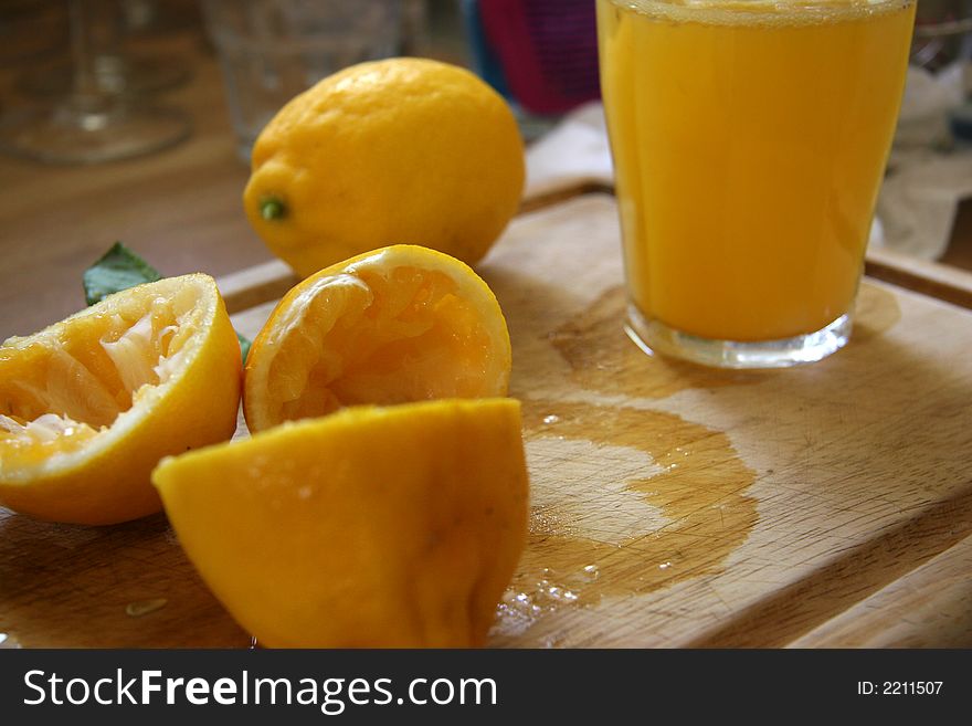 Squeezed lemons with glass full of juice. Squeezed lemons with glass full of juice