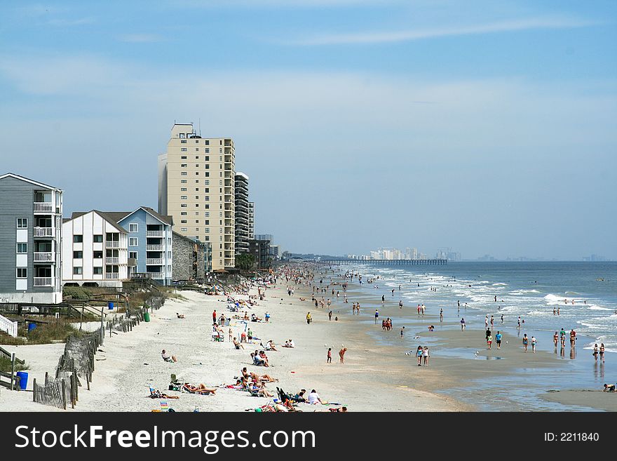 View of beach with people and houses,hotels. View of beach with people and houses,hotels