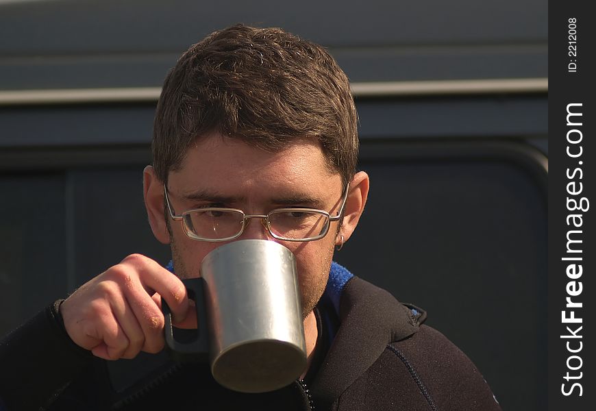 Man in wet suit drinking