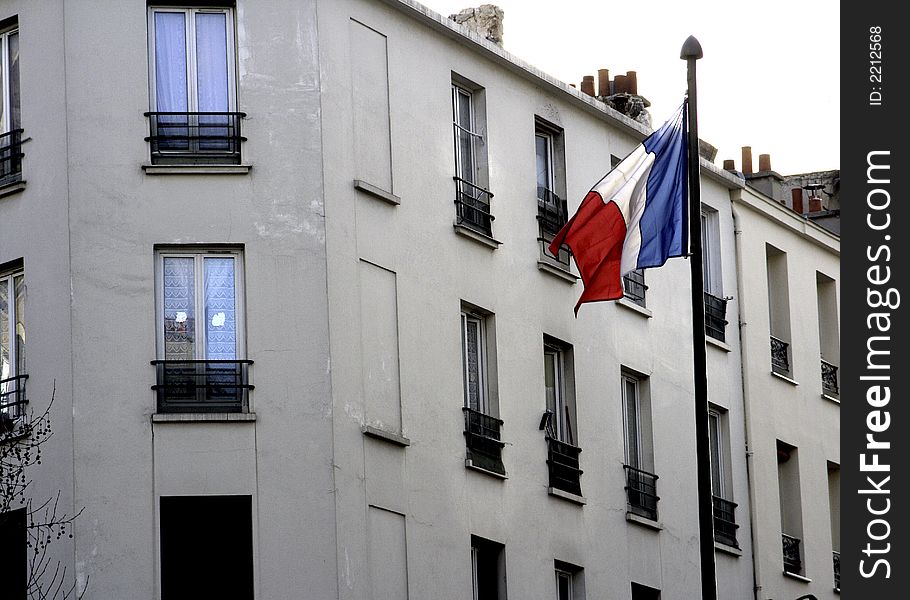 In Paris the French flag waves proudly near local residences. In Paris the French flag waves proudly near local residences