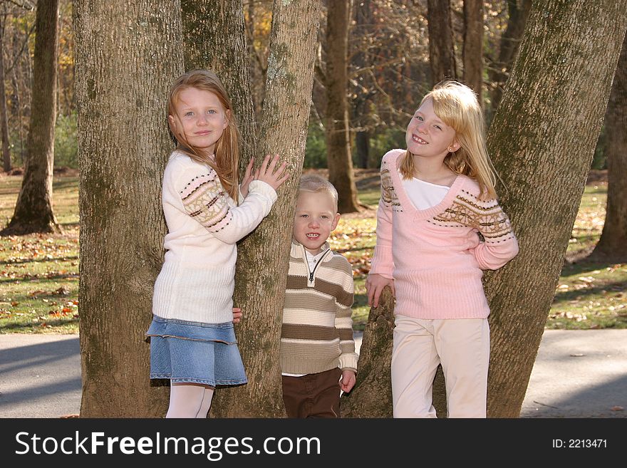 Two sisters and their brother standing in a tree. Two sisters and their brother standing in a tree