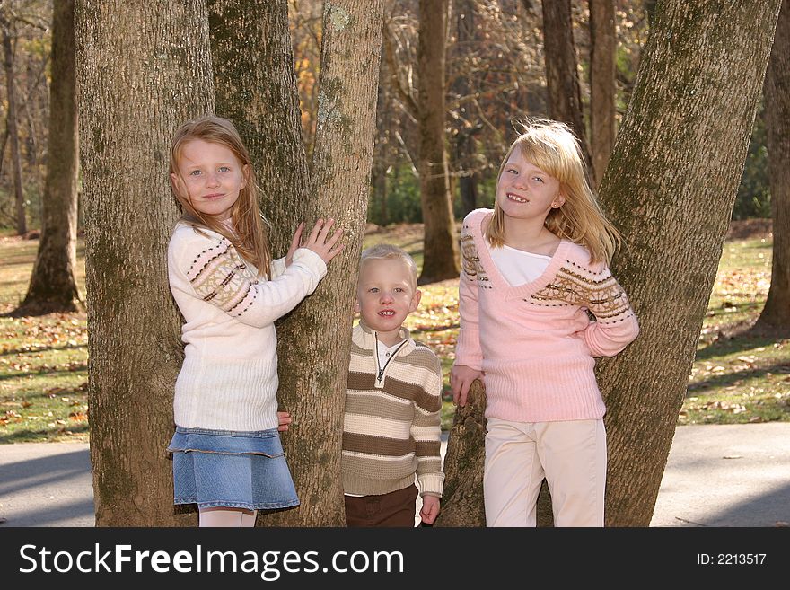 Two sisters and their brother standing in a tree. Two sisters and their brother standing in a tree