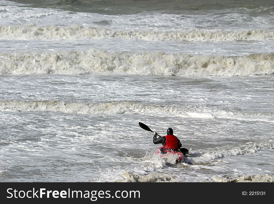 During flood a canoe is fighting against the waves. During flood a canoe is fighting against the waves.