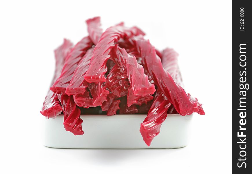 Red licorice candy over the white background