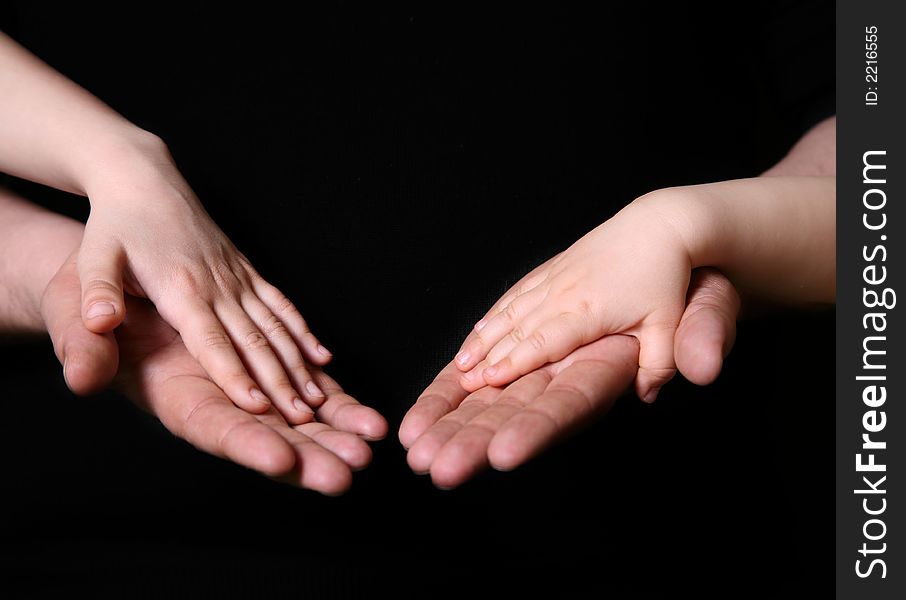 Hands of the father and his daughters on a dark background. Hands of the father and his daughters on a dark background