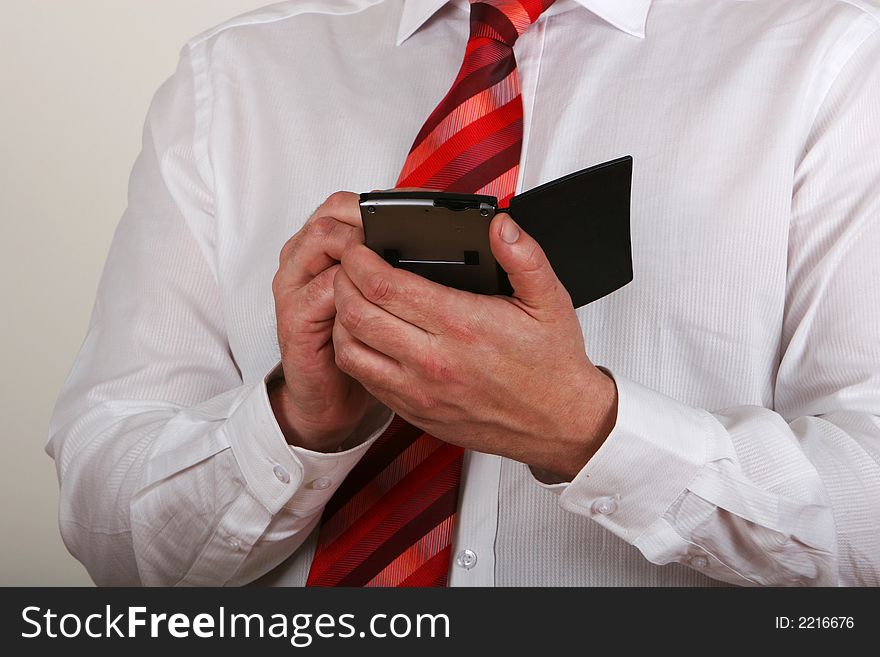 A man in shirt and tie writing on a pda. A man in shirt and tie writing on a pda