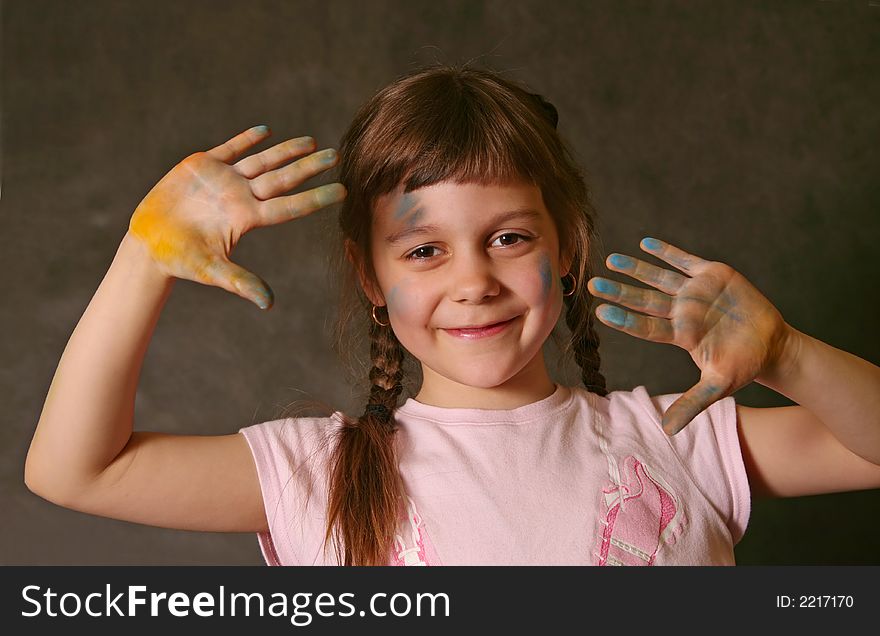 The good little girl. Hands and the face are soiled in a paint. The good little girl. Hands and the face are soiled in a paint