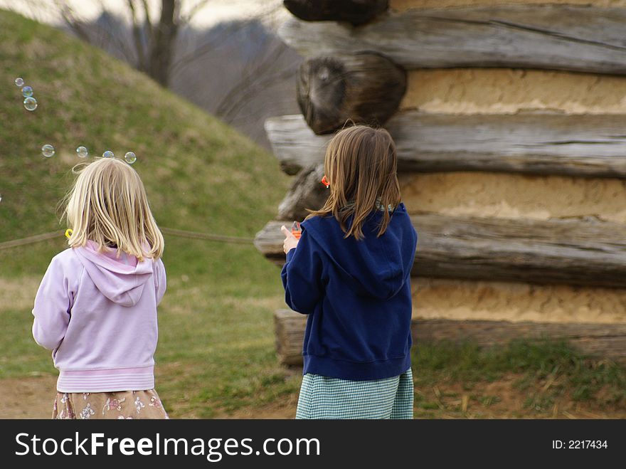 Two young girls playing with bubbles. Two young girls playing with bubbles