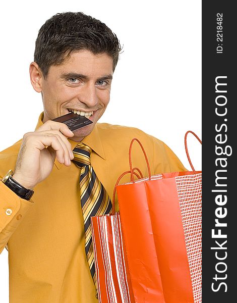 Happy man's carrying two paper bags. He's holding credit card by his teeth. Isolated on white in studio. Happy man's carrying two paper bags. He's holding credit card by his teeth. Isolated on white in studio.