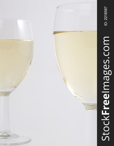 Two glasses filled with white wine in detail. Two glasses filled with white wine in detail.
