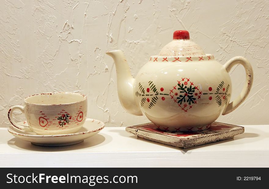 White teapot and cup on a shelf. White teapot and cup on a shelf