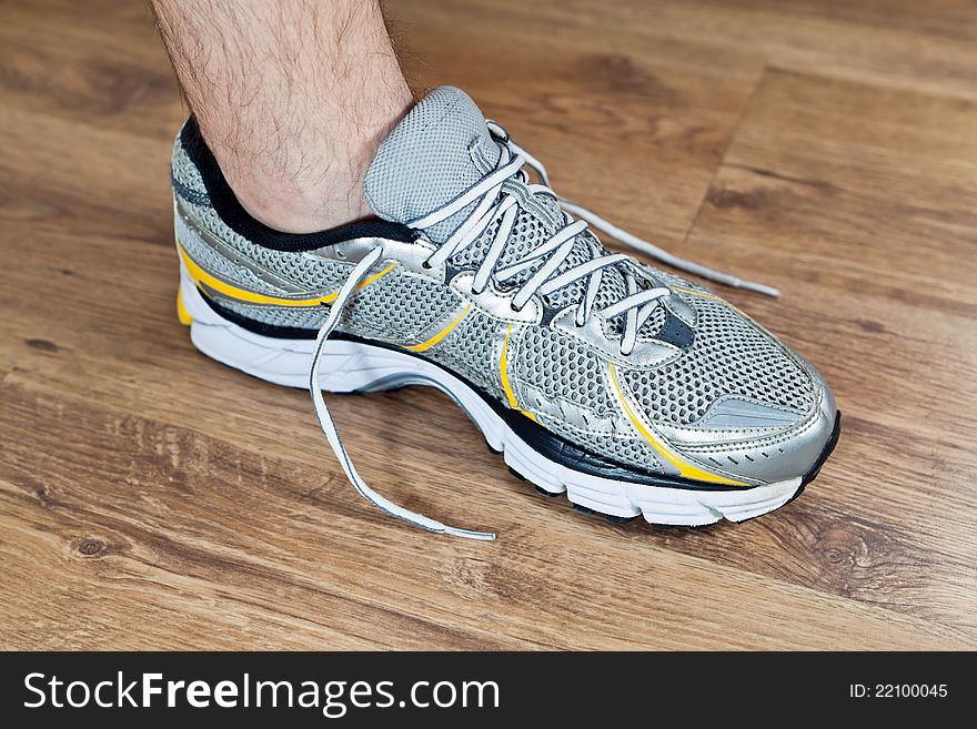 Man tying sports shoe at gym before workout, exercising indoors. Man tying sports shoe at gym before workout, exercising indoors