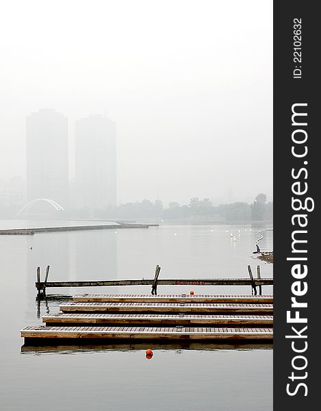 Floating docks are visible through the mist surrounding Sunnyside Beach on Lake Ontario in downtown Toronto. The Pierre Elliott Trudeau pedestrian bridge is visible in the distance - part of the Martin Goodman Waterfront Trail. Floating docks are visible through the mist surrounding Sunnyside Beach on Lake Ontario in downtown Toronto. The Pierre Elliott Trudeau pedestrian bridge is visible in the distance - part of the Martin Goodman Waterfront Trail.
