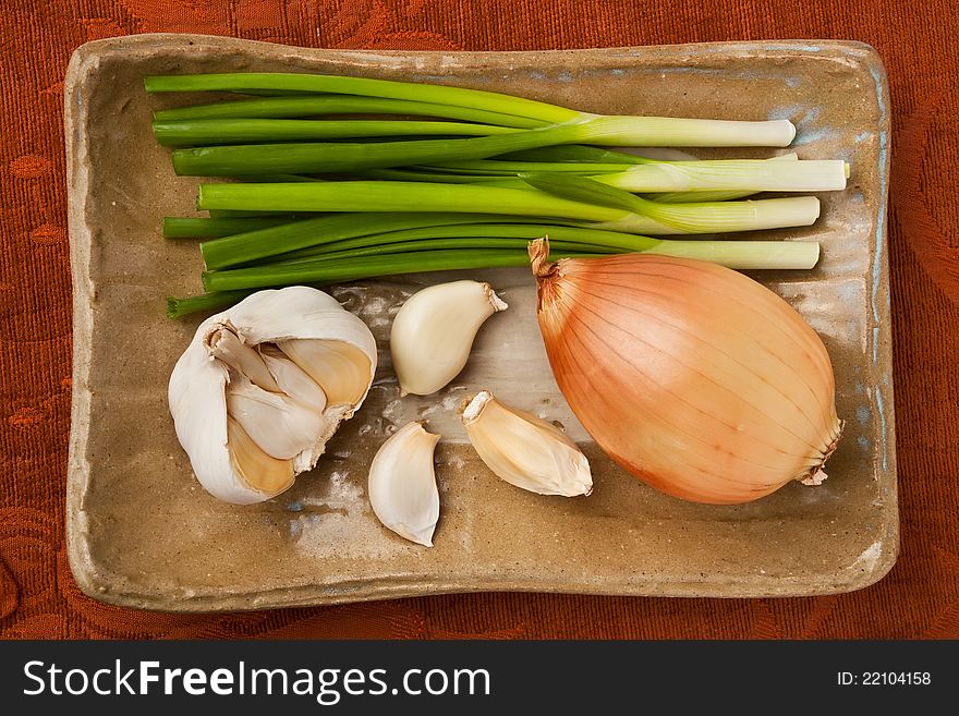 Onions and garlic on a brown plate