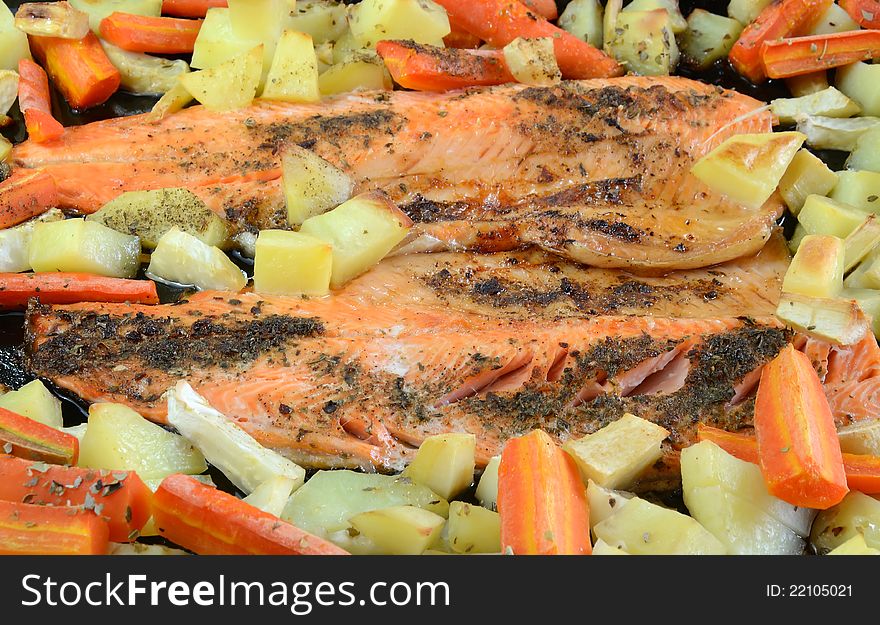 Fresh baked trout fish with chopped vegetables on a teflon form. Fresh baked trout fish with chopped vegetables on a teflon form