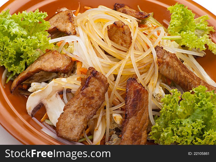 Fried Noodles with Beef and Vegetables. Garnished with Salad Leaf