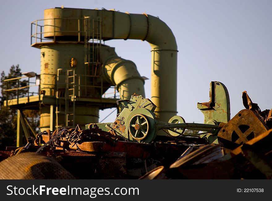 Machine behind the scrap heap works with fragmentation of the metal. Machine behind the scrap heap works with fragmentation of the metal