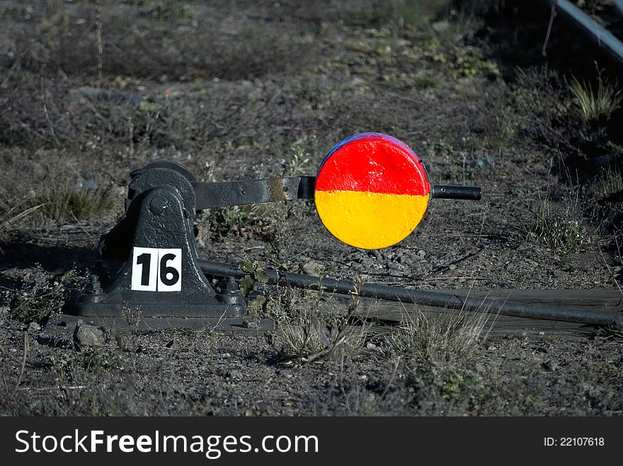 Railroad switch marked with number 16, with colorful red and yellow sign. Railroad switch marked with number 16, with colorful red and yellow sign