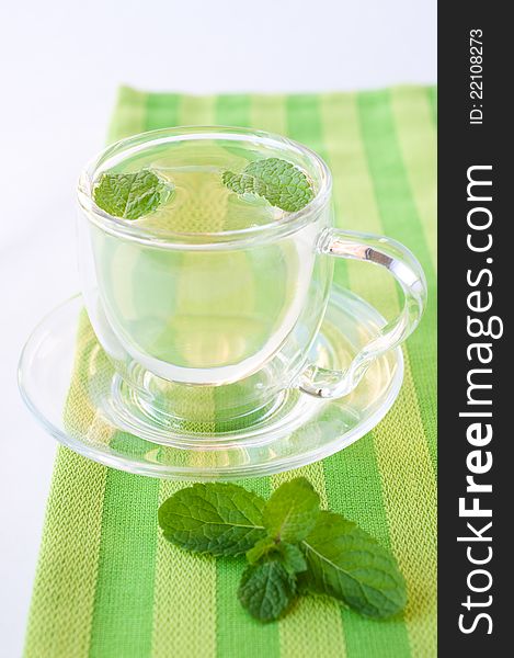 Herbal green tea in a glass cup on a green napkin. Herbal green tea in a glass cup on a green napkin