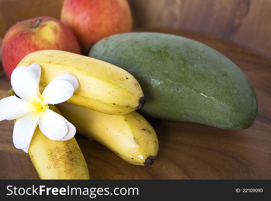 Tropical fruits banana,mango and apples on wooden tray. Tropical fruits banana,mango and apples on wooden tray