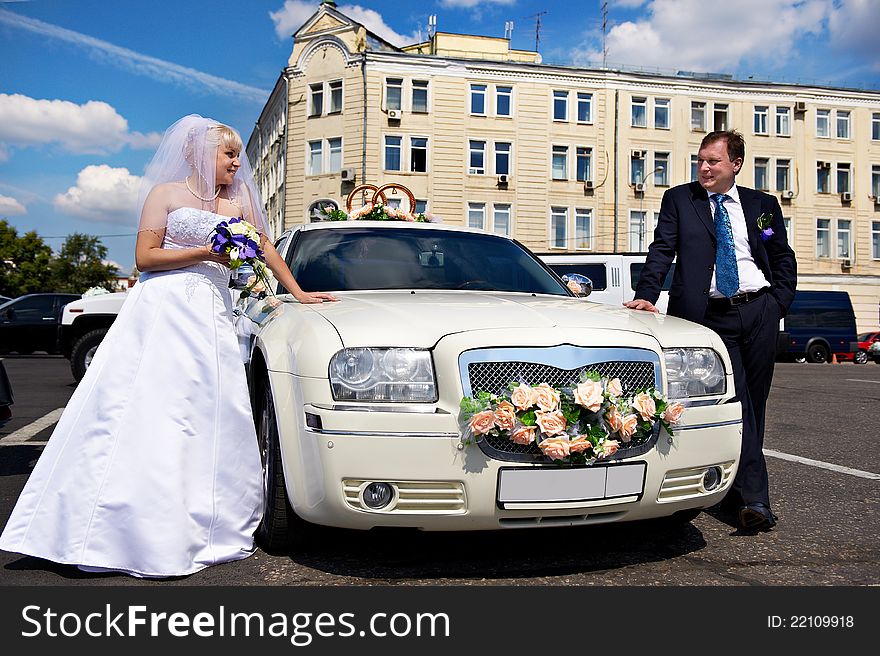 Happy bride and groom about wedding limousine