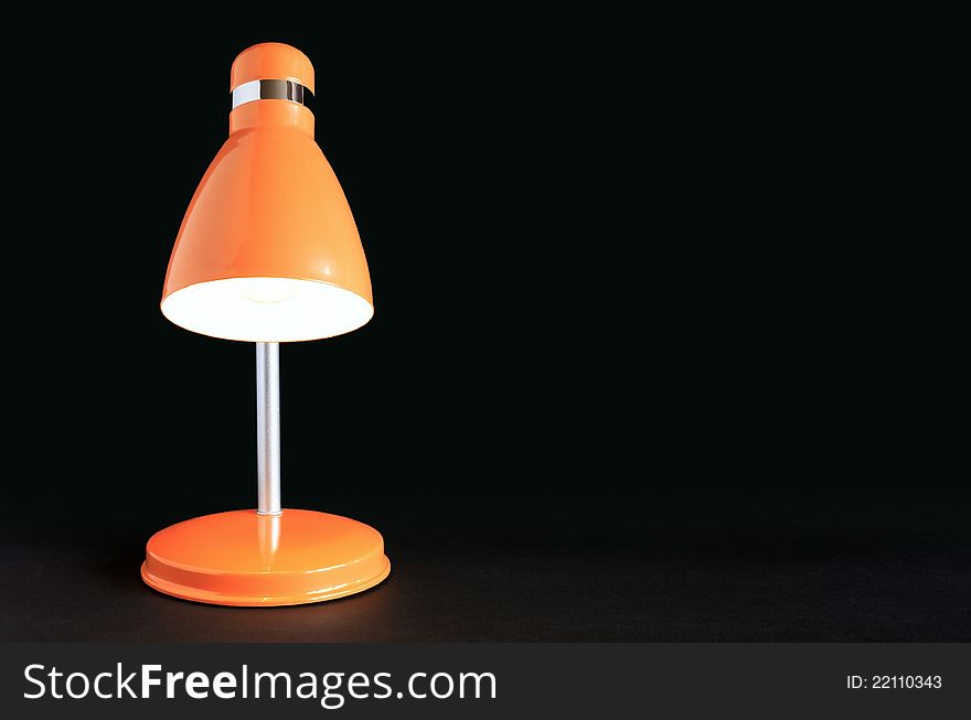 Yellow table glowing lamp on dark background with free space for text