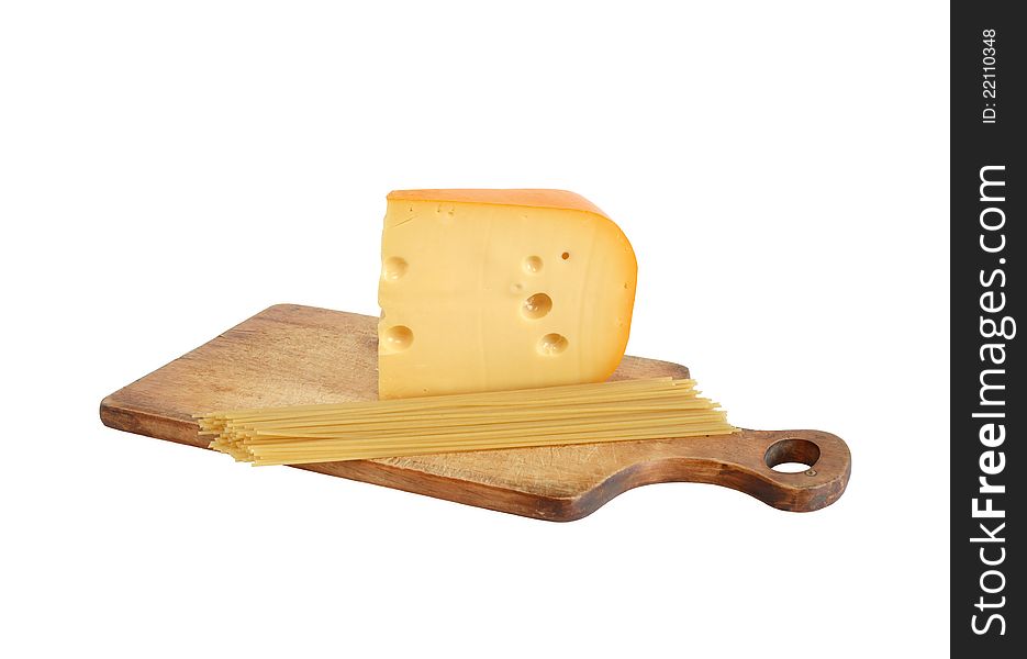 Big piece of cheese near raw spaghetti on cutting board. Isolated with clipping path. Big piece of cheese near raw spaghetti on cutting board. Isolated with clipping path