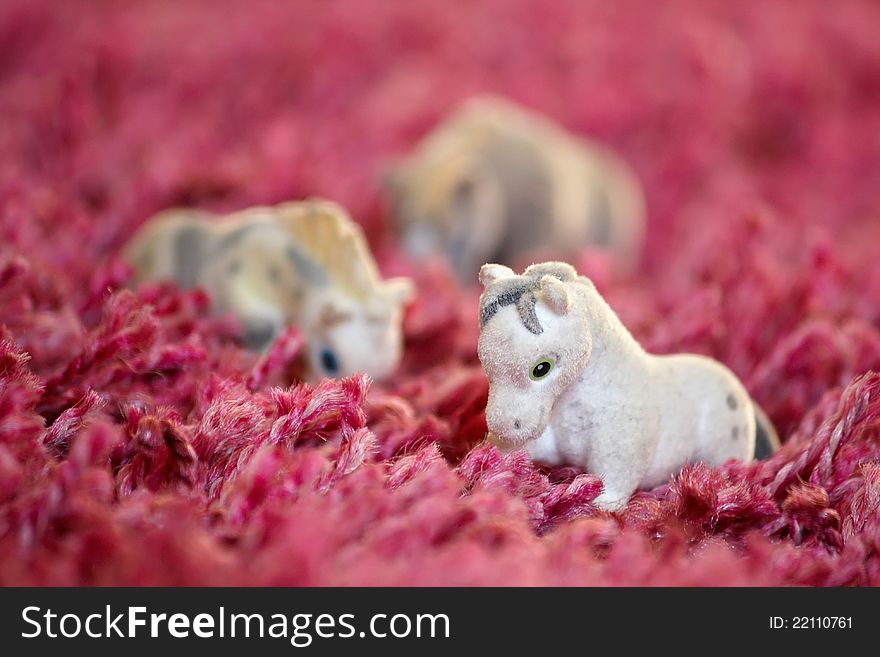 Toys horses lined up on the carpet