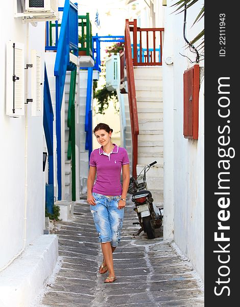 Young white caucasian woman walking white washed and cosy little street in the greek island of mykonos. Young white caucasian woman walking white washed and cosy little street in the greek island of mykonos