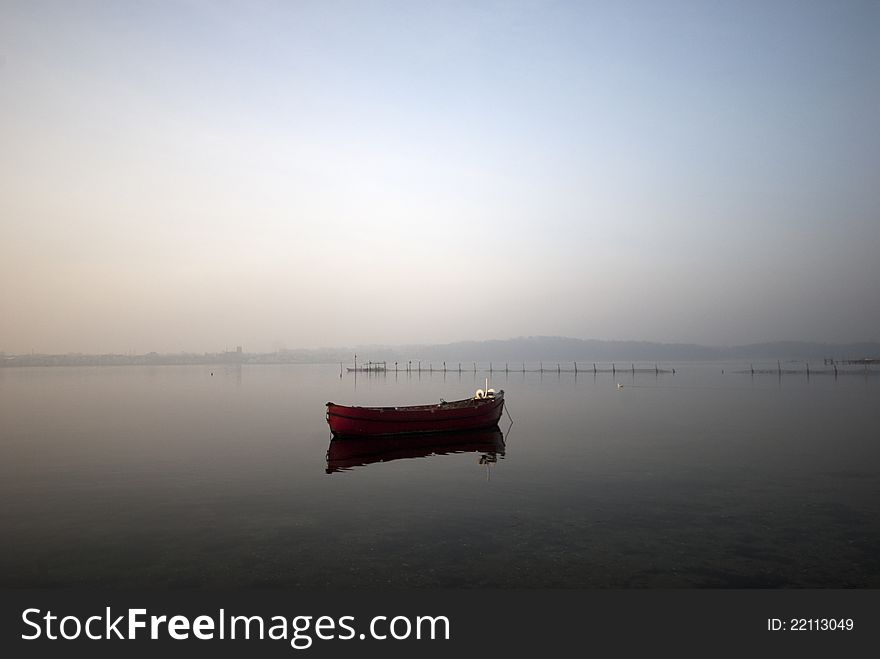 Red fishing boat and fish trap in Littel Belt a foggy sunny morning. Red fishing boat and fish trap in Littel Belt a foggy sunny morning.