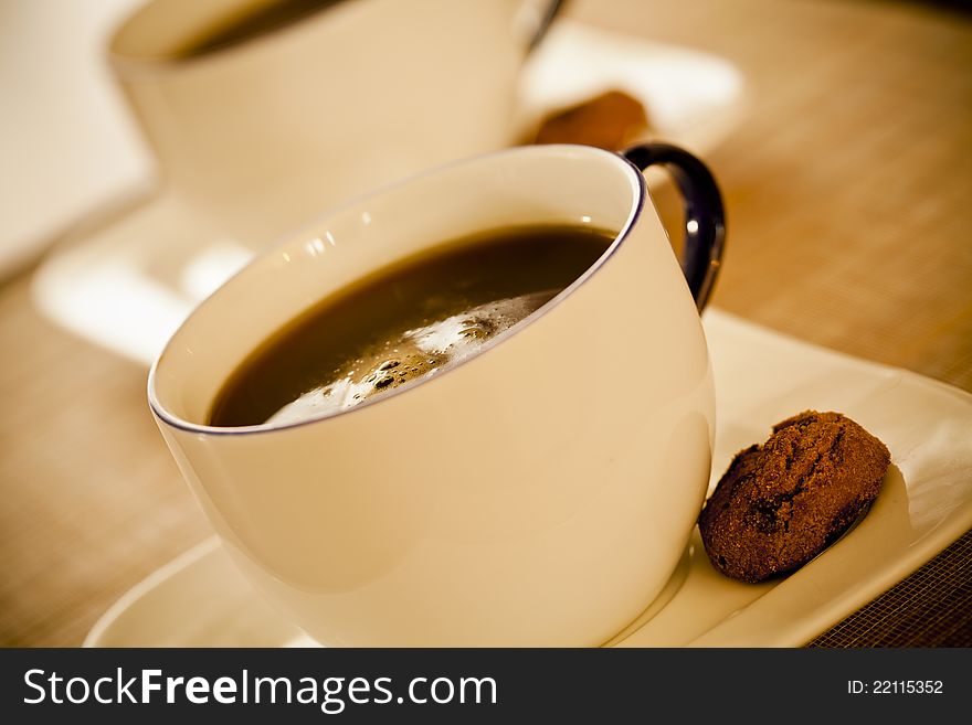 Close up photograph of two coffee cups with cookies. Close up photograph of two coffee cups with cookies