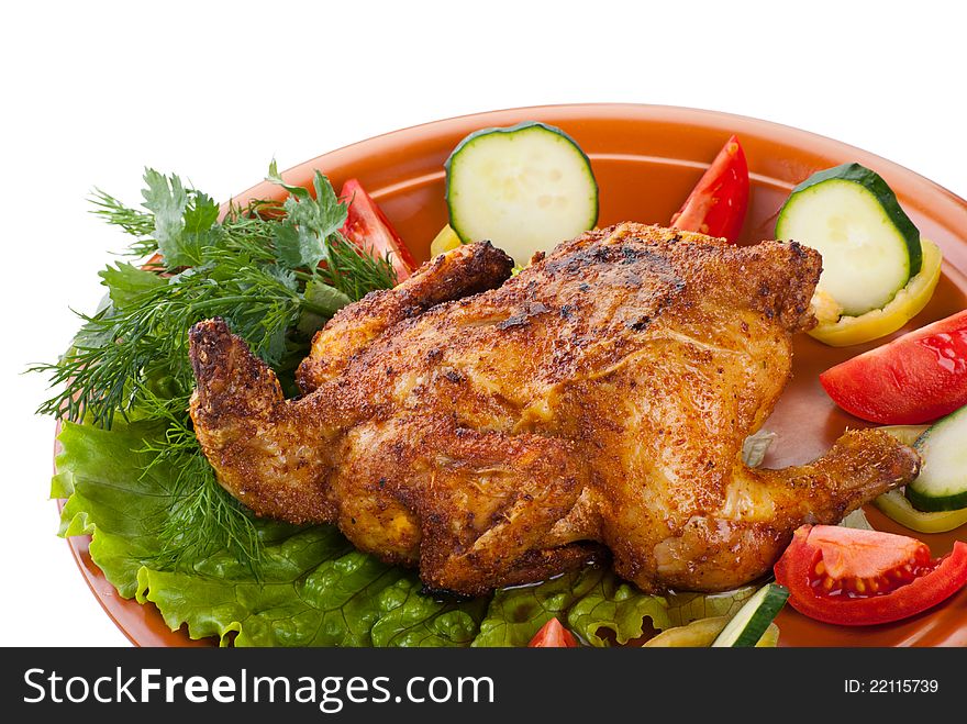 Fresh grilled whole chicken with cucumber, raw tomatoes on plate with leaf lettuce isolated over white background. Fresh grilled whole chicken with cucumber, raw tomatoes on plate with leaf lettuce isolated over white background