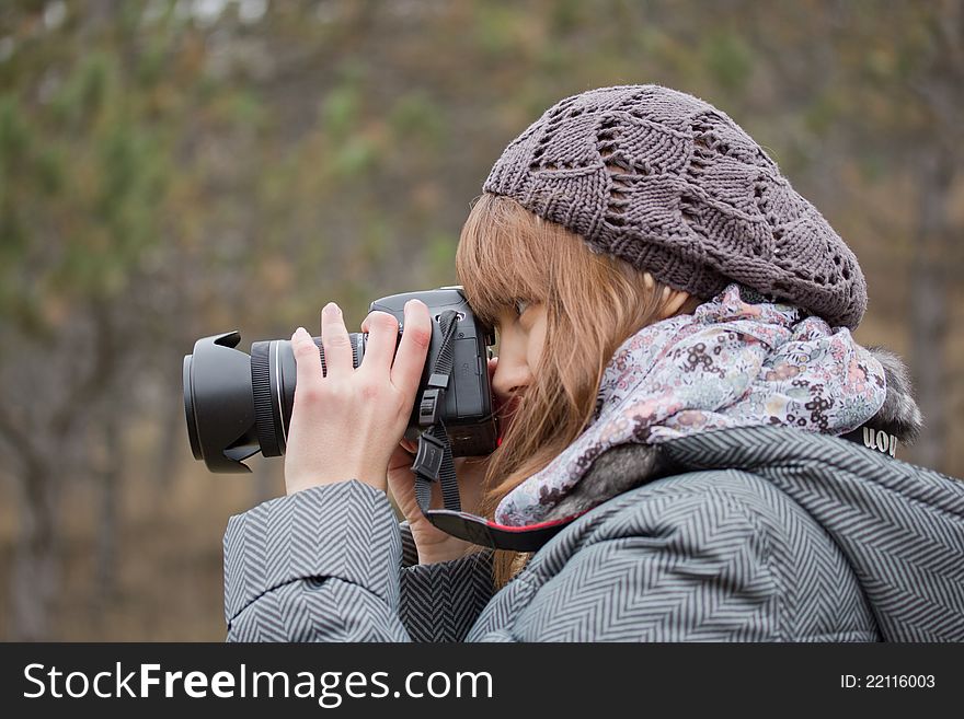 Young girl photographing something in the park. Young girl photographing something in the park