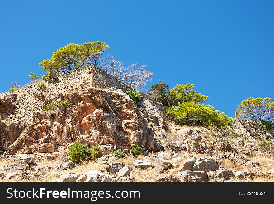 Blue sky, the old city walls, green plants, stone slope