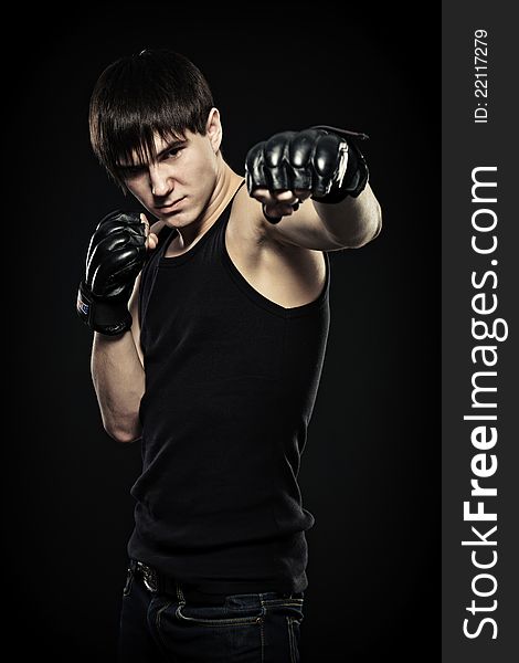 Guy in the fighting gloves, isolated black background. Guy in the fighting gloves, isolated black background.