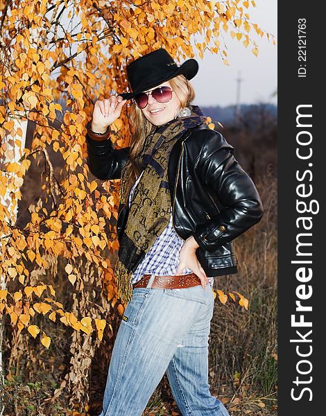 Young girl dressed like a cowgirl over autumnal background. Young girl dressed like a cowgirl over autumnal background