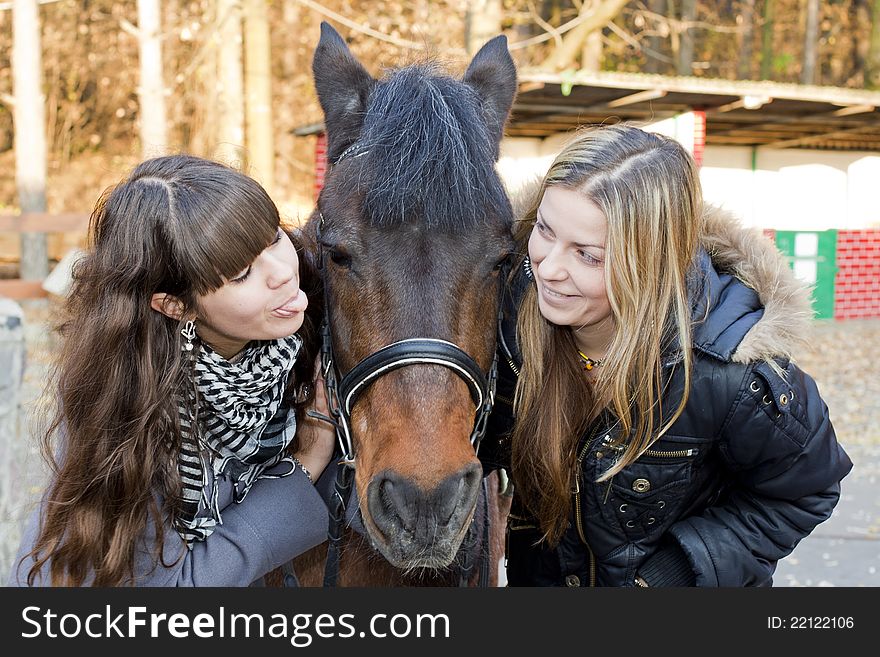 Two girls playing with horse