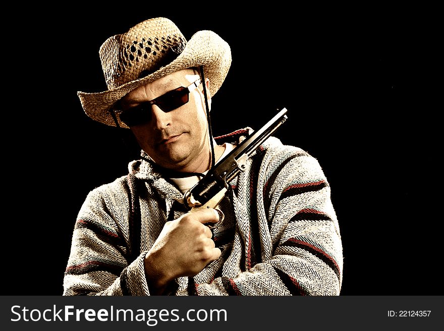 Caucasian man with tough expression holding a handgun wearing Mexican style clothes shot with studio lighting. Caucasian man with tough expression holding a handgun wearing Mexican style clothes shot with studio lighting.