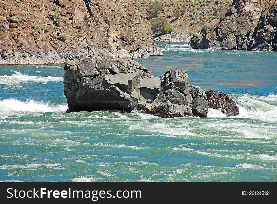 Large rock in rapid flowing water. Large rock in rapid flowing water