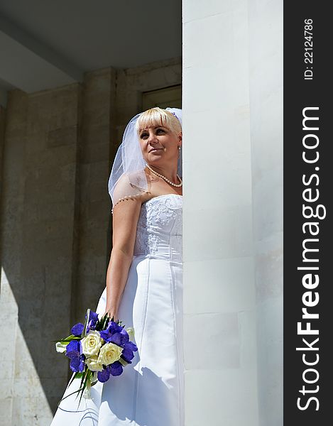 Happy bride near white columns outdoor