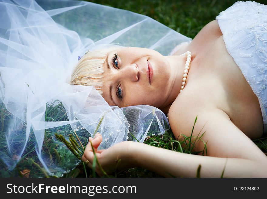 Portrait Beautiful Bride Lying On Grass