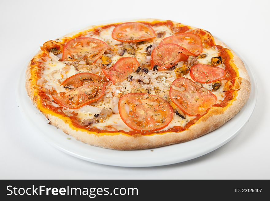Round fresh pizza on white plate