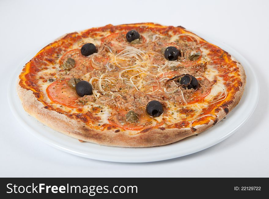 Round fresh pizza on white plate