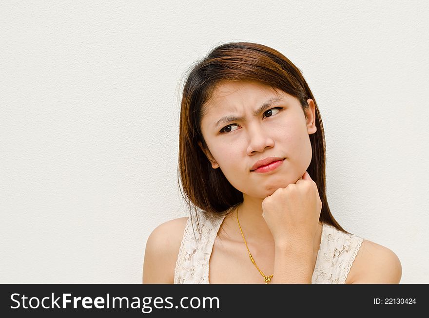 Young cute asian girl thinking on white background