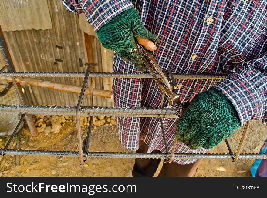 Thai worker infix iron grid by pliers at work site