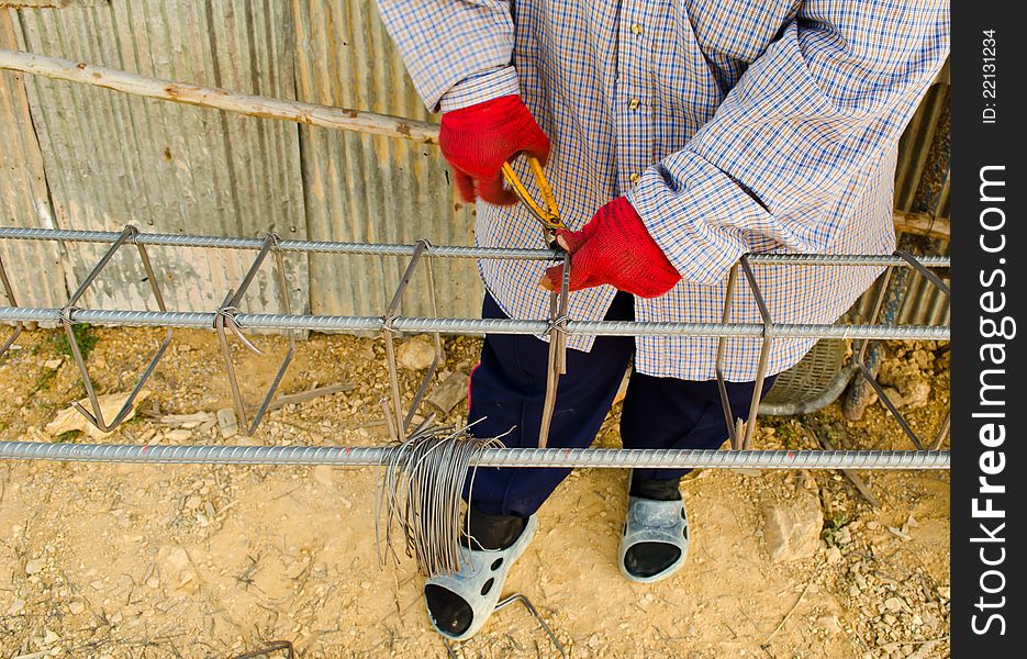 Thai worker infix iron grid by pliers at work site