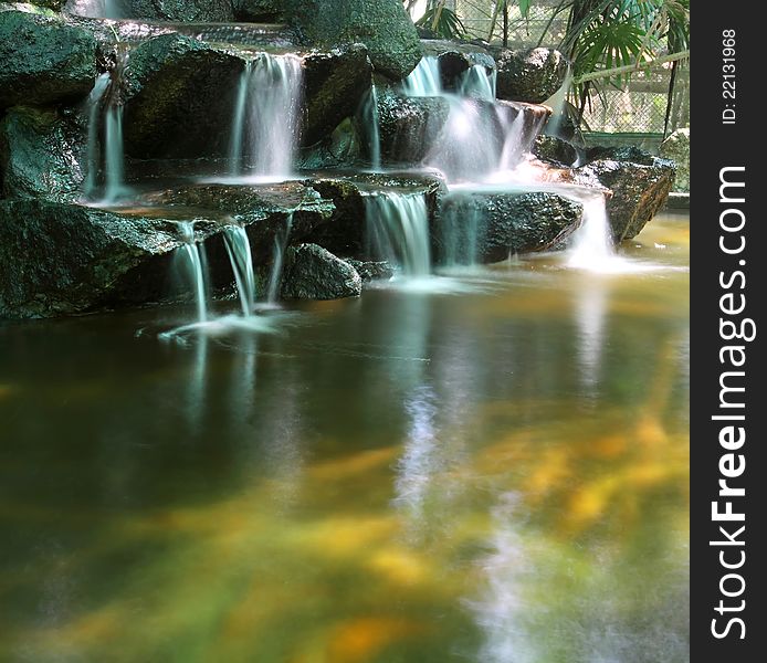 Koi fish pond with waterfalls in the zoo